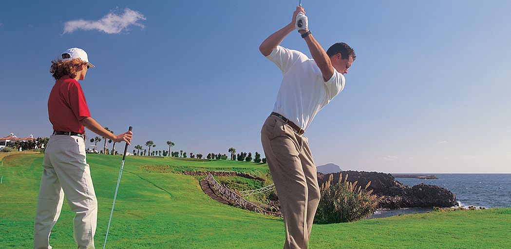 Golfers playing golf at Golf del Sur in Tenerife with views of the mountains.
